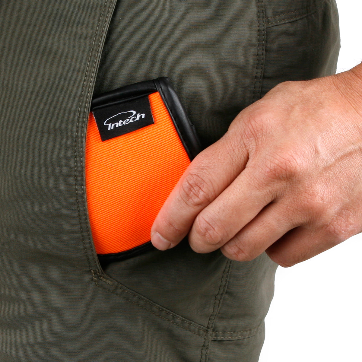 person placing an orange Intech Squeaky Clean Pocket Golf Ball Washer inside their left pocket