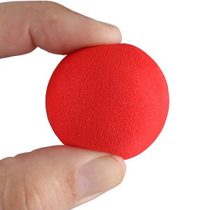 person squeezing a soft red Intech Foam Golf Ball with thumb and forefinger