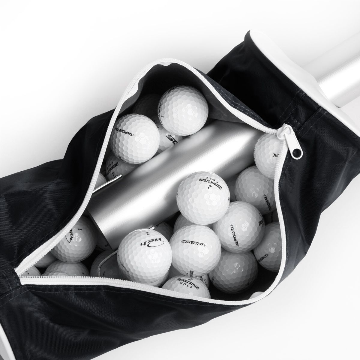 golf balls inside the zippered compartment of a black Intech Golf Ball Shag Bag